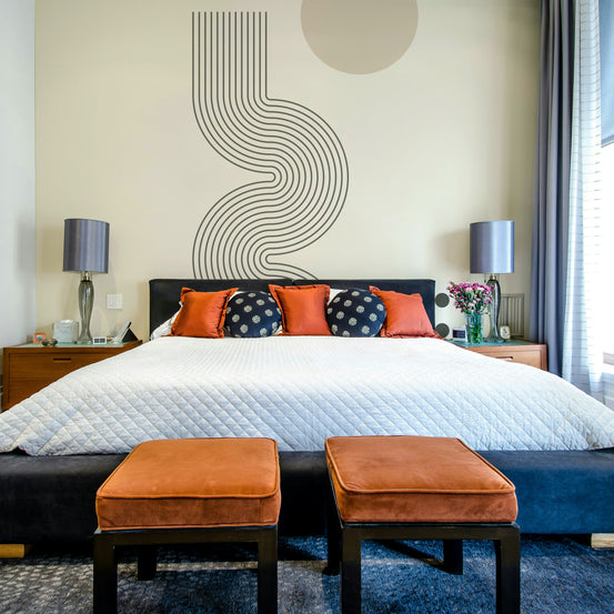 Retro Geometric Flow wallpaper mural of gray wavy lines above a blue bed with orange velvet pillows