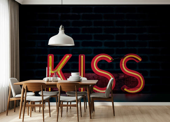Neon Kiss wallpaper mural with red KISS sign on dark brick above a wooden dining table in a dining room