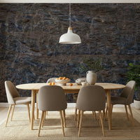Rocky Terrain wallpaper mural in dark blue and brown stone behind an oval wood dining table with beige chairs