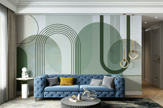 Sage Green Archways wallpaper mural behind a blue tufted sofa with mustard cushions and gold ring pendants in a living room