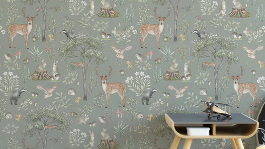 Sage Green Wildlife wallpaper with deer, badgers and owls behind a dark wood side table in a kids room