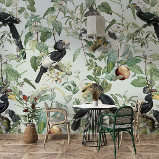 Savannah wallpaper mural of hornbills on sage above a round white table with rattan chairs in a dining nook