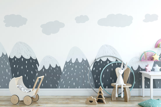 Scandinavian Mountain wallpaper mural with grey snow-capped peaks and clouds in a kids room with wooden toy pram and bunny chair