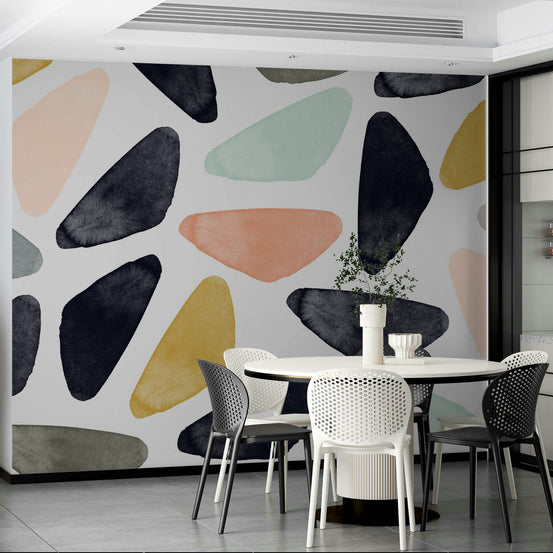 Scandinavian wallpaper mural of navy and peach organic shapes beside a round white table with mesh chairs