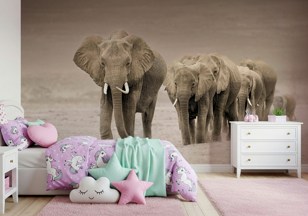 Elephant Journey wallpaper mural of a sepia elephant herd above a girls bed with pink unicorn bedding