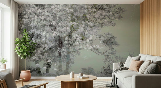 Floral Canopy Serenity wallpaper mural of white blossoms on sage green behind a grey sofa in a living room