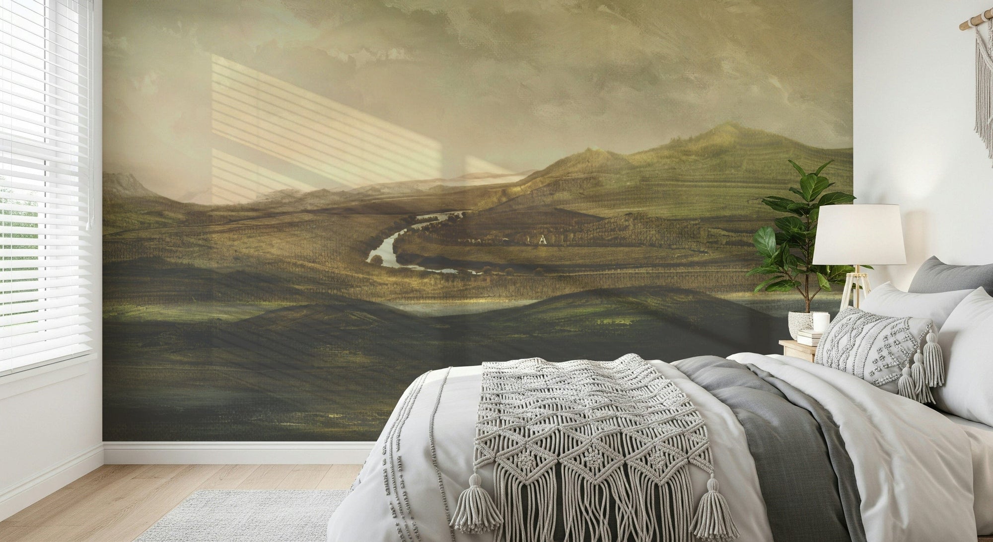 Painted Valley Vista wallpaper mural of a river valley in a bedroom with gray bedding and a macrame throw