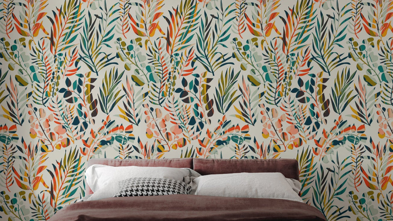 Botanical Fiesta wallpaper mural of colorful watercolor leaves above a bed with a dusty-rose headboard in a bedroom