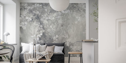 Slate Leaf Silhouette Panorama wallpaper mural in soft gray florals behind a dark sofa in a living room