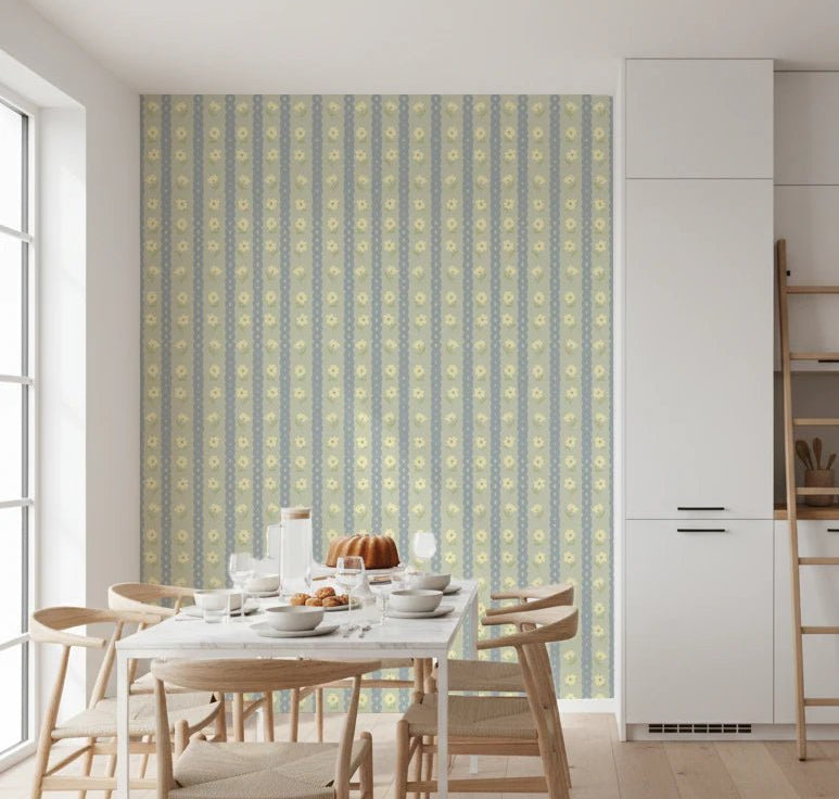 Soft Daisy Stripes wallpaper with sage and blue stripes and yellow daisies above a white dining table and wishbone chairs in a kitchen