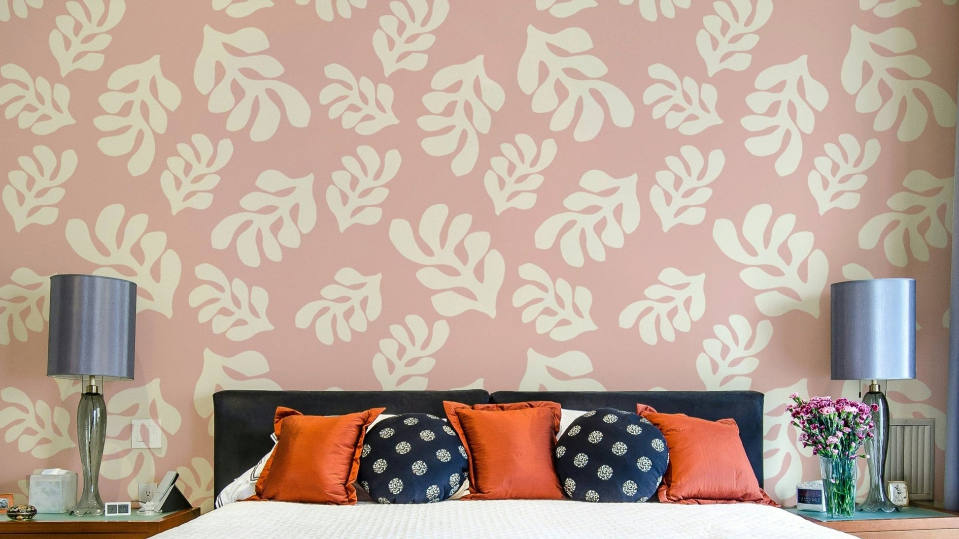A photo-realistic wall mural with a repeating pattern of soft pink leaves.

