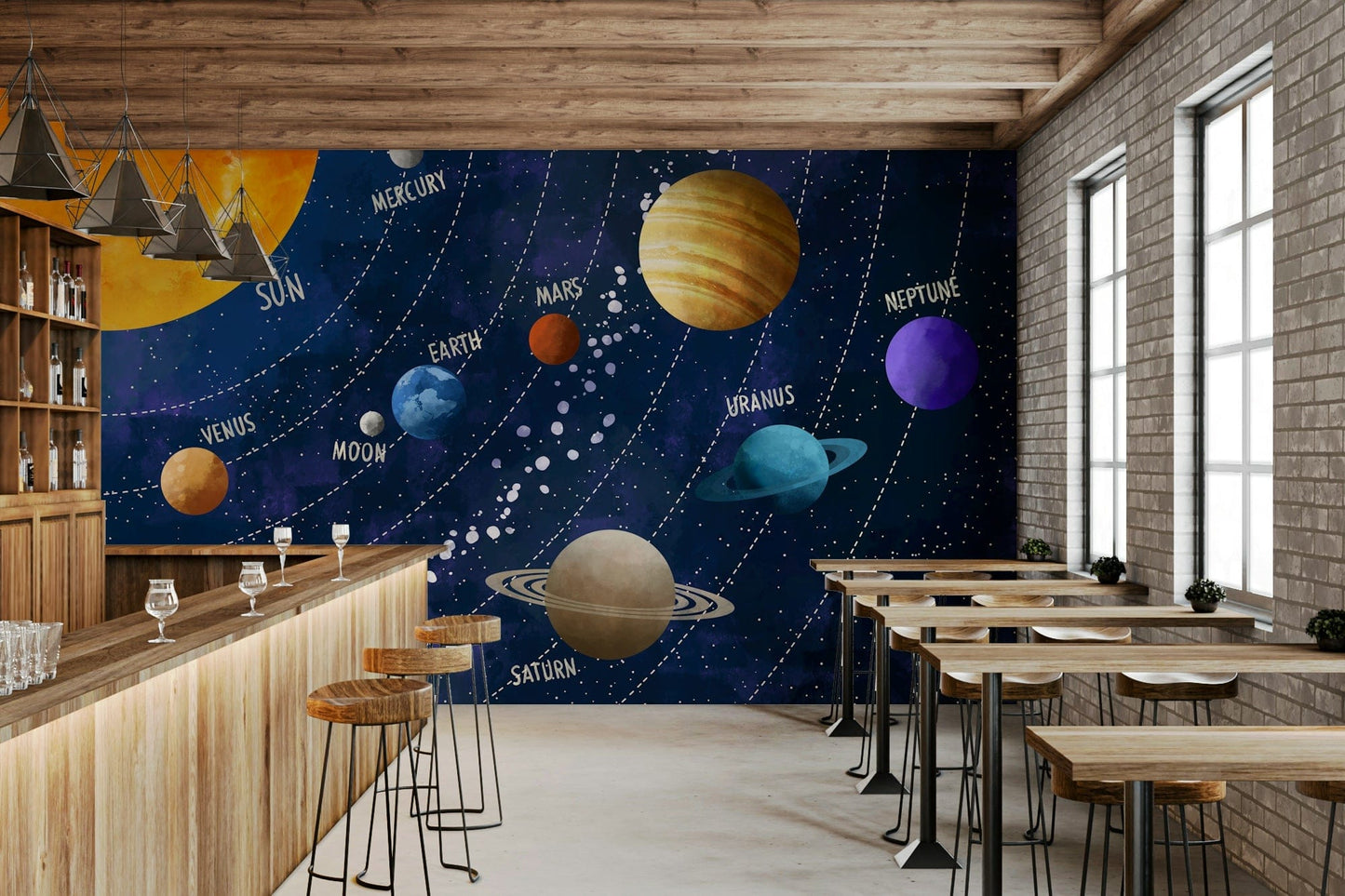 Solar System Adventure wallpaper mural of the labeled planets behind a wood bar counter with stools and brick wall in a cafe