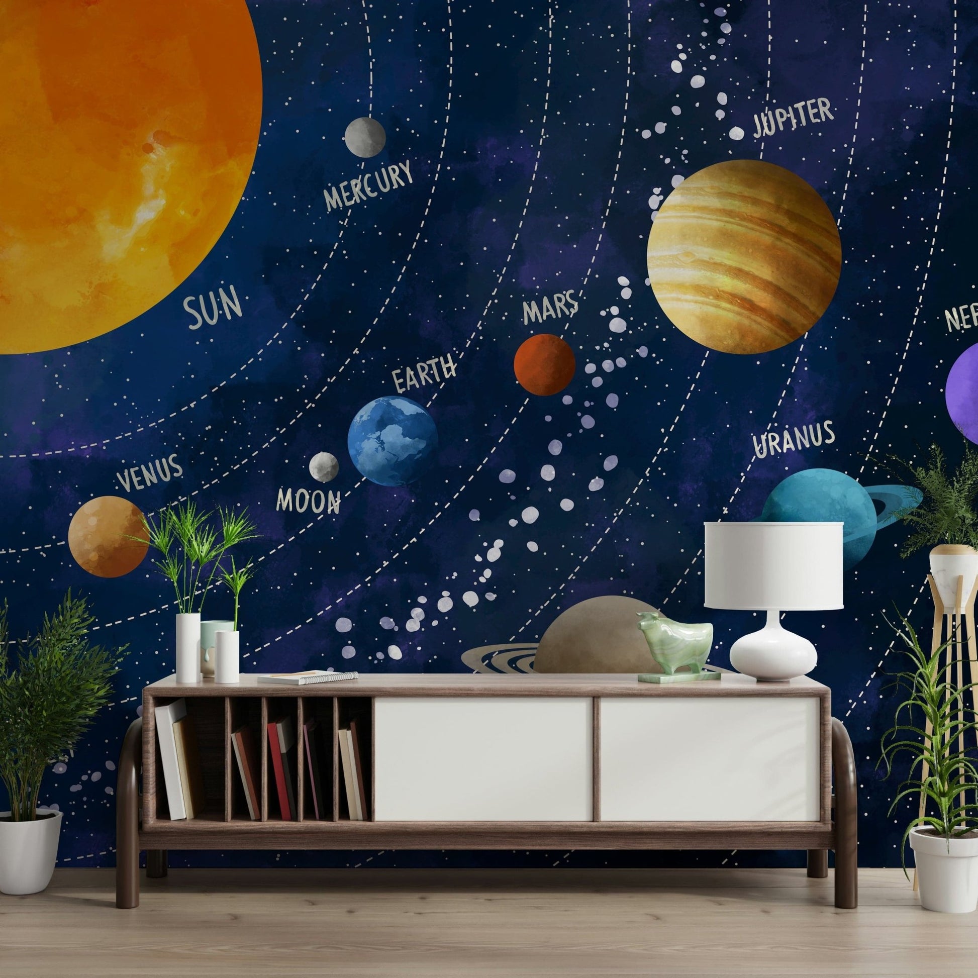 Solar System Adventure wallpaper mural of the planets in space behind a wood sideboard with books and plants in a living room