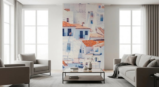 Spanish Townscape mural of whitewashed houses and terracotta roofs behind a beige sofa and armchair