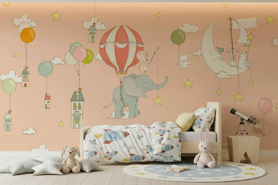 Starry Sky Adventures wallpaper mural of a teddy on an elephant and balloon in a peach sky over a wood bed with rocket bedding