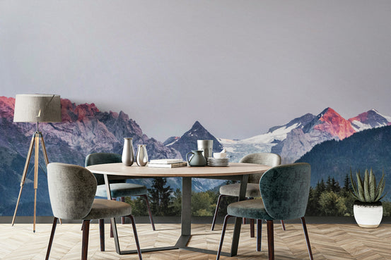 Sunset Mountain Vista wall mural with red-lit peaks behind a round dining table and grey velvet chairs