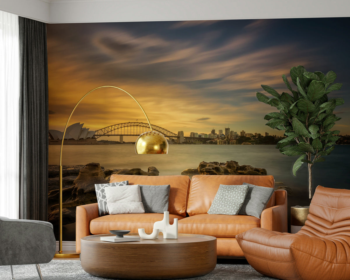 Sydney Sunset wallpaper mural of the harbour, Opera House and bridge above a tan leather sofa and arc lamp