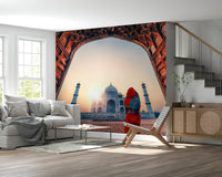Grand arch framing Taj Mahal at sunset wall mural serene peaceful atmosphere.