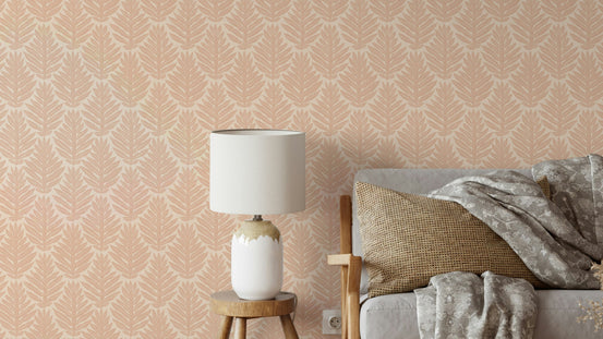 Terracotta Leaf Scallop Jewel Jungle wallpaper in a living room behind a grey sofa with a white lamp on a wood stool