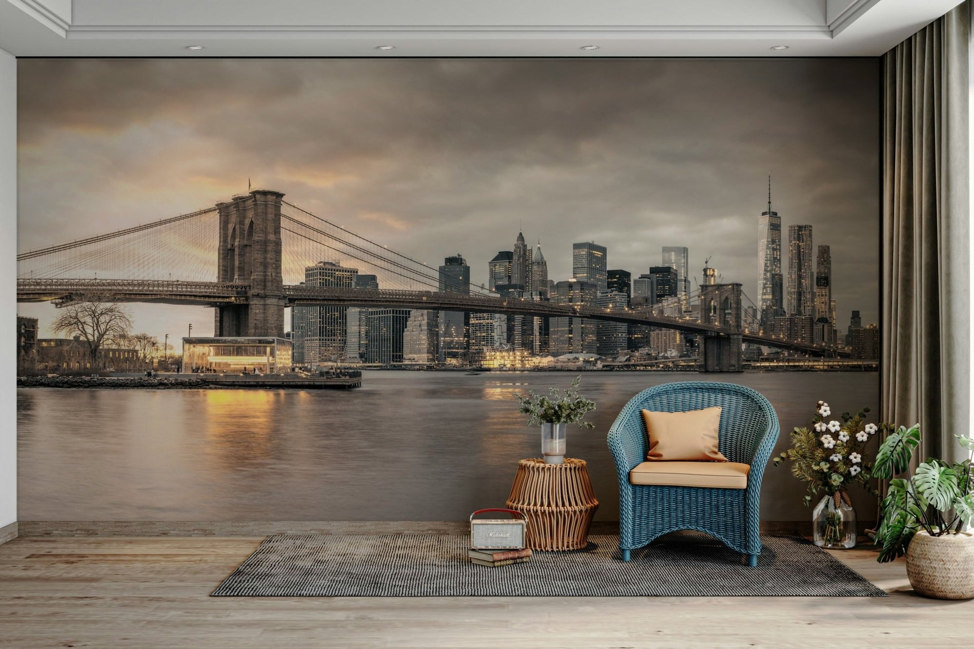 The Majestic Brooklyn Bridge wallpaper mural at dusk behind a blue wicker armchair in a cozy living room