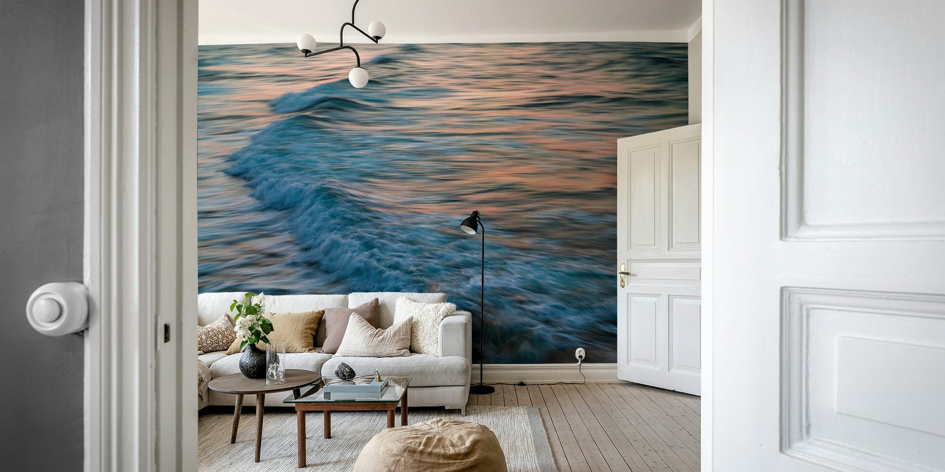 A contemporary living room with a large ocean wave wall mural.

