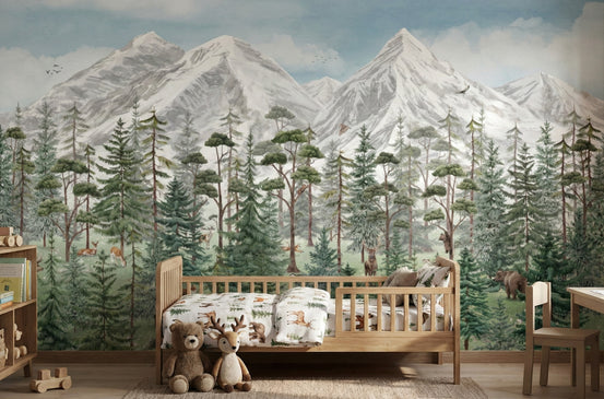 Tranquil Alpine Forest wallpaper mural with snowy mountains, green pine trees and deer behind a wooden toddler bed in a kids room