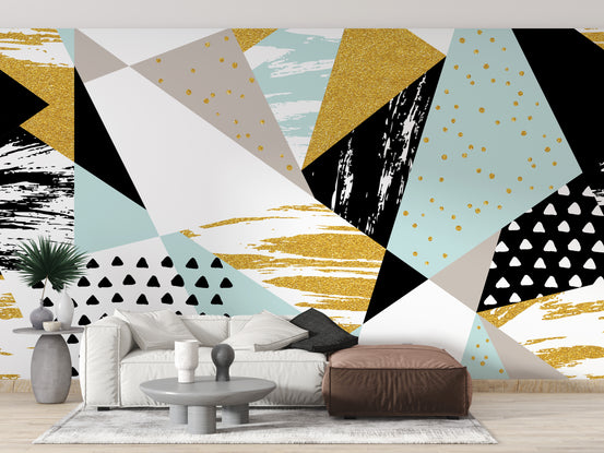 Triangle Shape Geometric wallpaper mural in gold, mint and black behind a white sofa and brown leather pouf in a living room