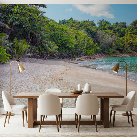 Tropical Beach Haven wall mural showing a sandy cove and green jungle behind a wood dining table in a dining room
