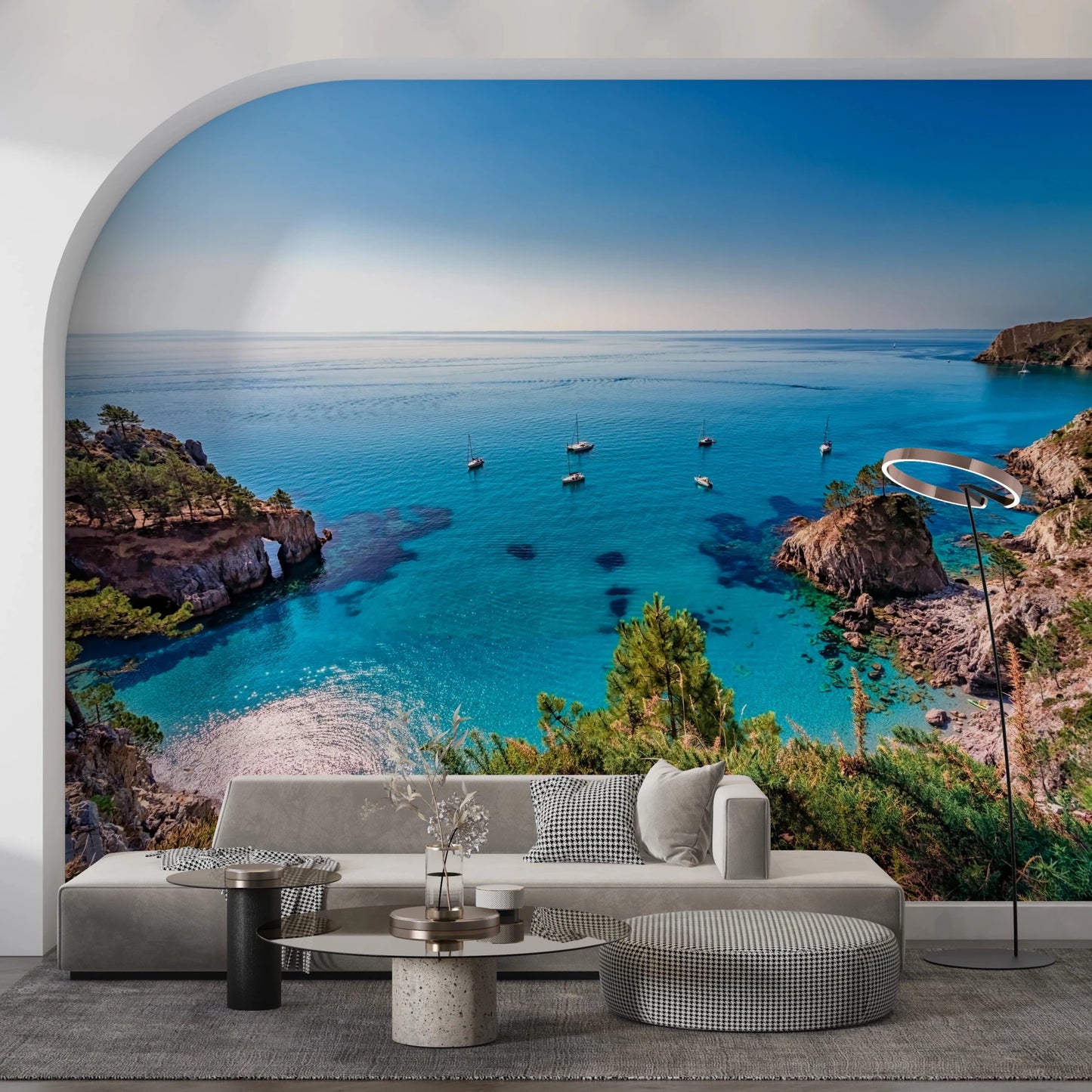 Turquoise Cove Escape wallpaper mural in an arched alcove behind a grey sofa and ring floor lamp