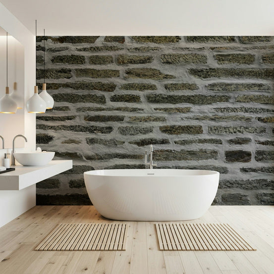 Urban stone wallpaper mural in a bathroom with a white freestanding tub and floating double vanity