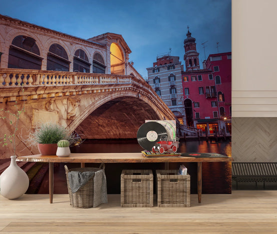 Venice at Dusk wall mural of the Rialto Bridge at twilight above a wood console with baskets