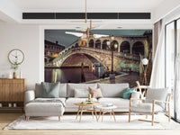 Grand Canal view, arched stone Rialto Bridge wallpaper for walls, dramatic lighting.