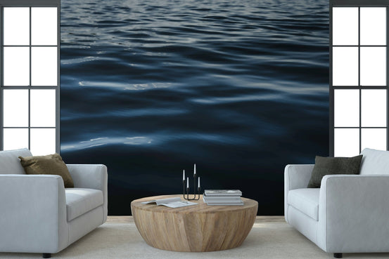 Water Ripples wallpaper mural of dark blue rippling water between two white armchairs in a living room