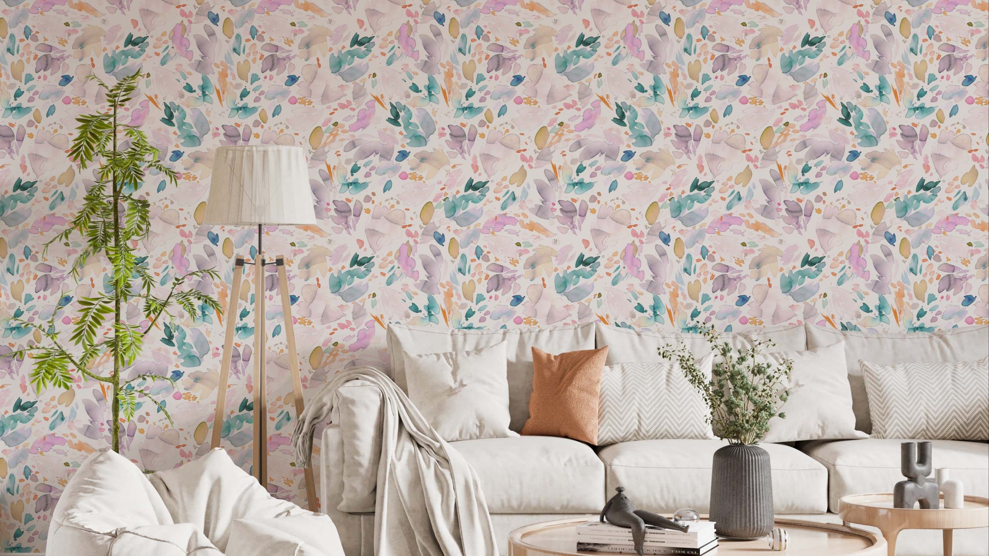 Watercolor Abstract Petals wallpaper in pastel pink and teal behind a cream sofa and tripod lamp in a living room
