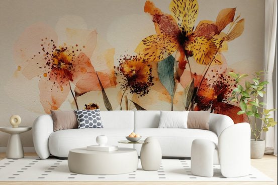 Watercolor Bloom wallpaper mural of warm amber and peach flowers behind a curved white sofa in a living room