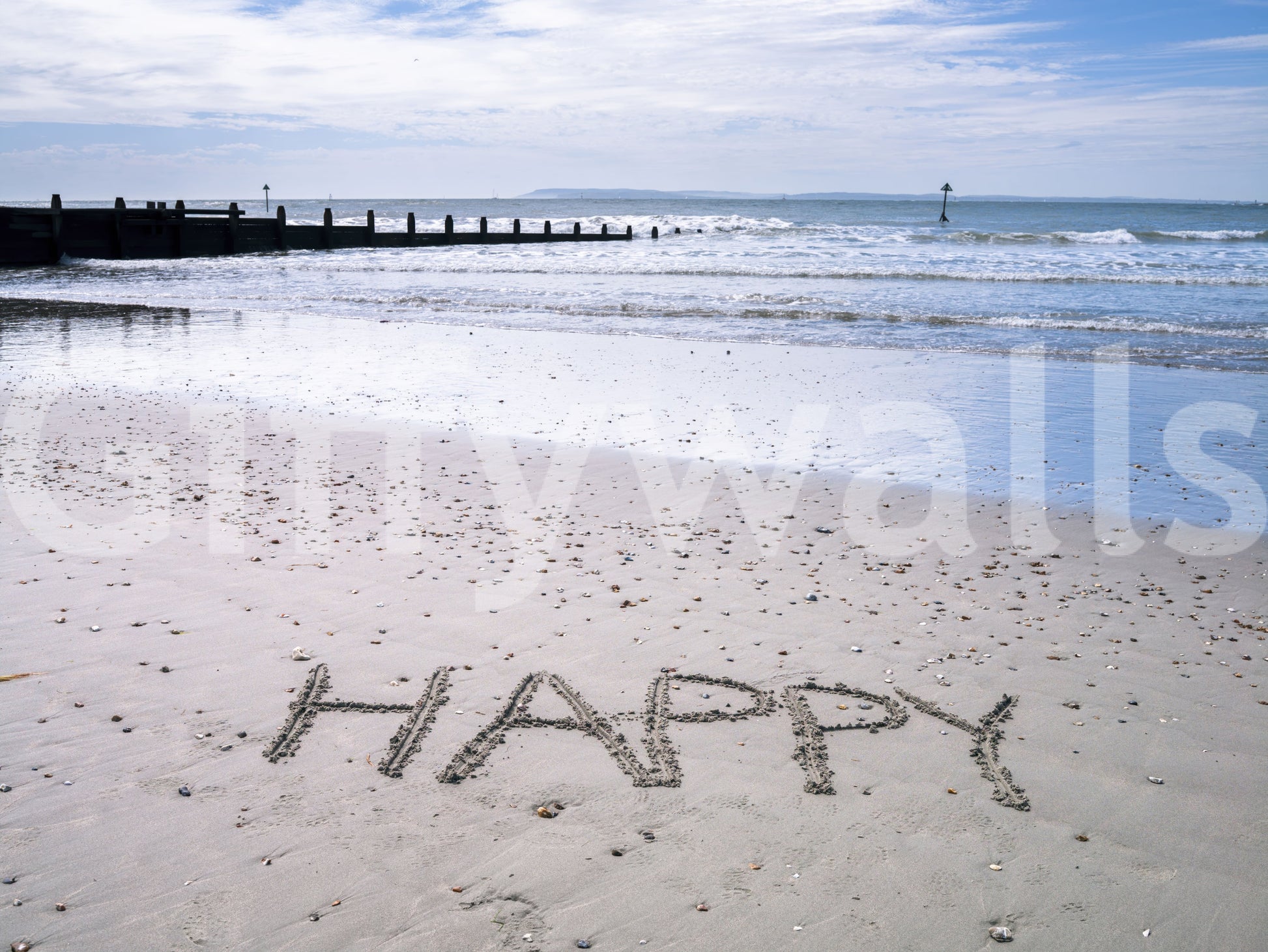 Joyful word etched Happy Beach wallpaper vast sandy expanse.