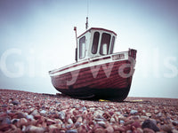 Boat Resting on Pebbled Strand, dark wooden vessel, rocky ground, wall covering.