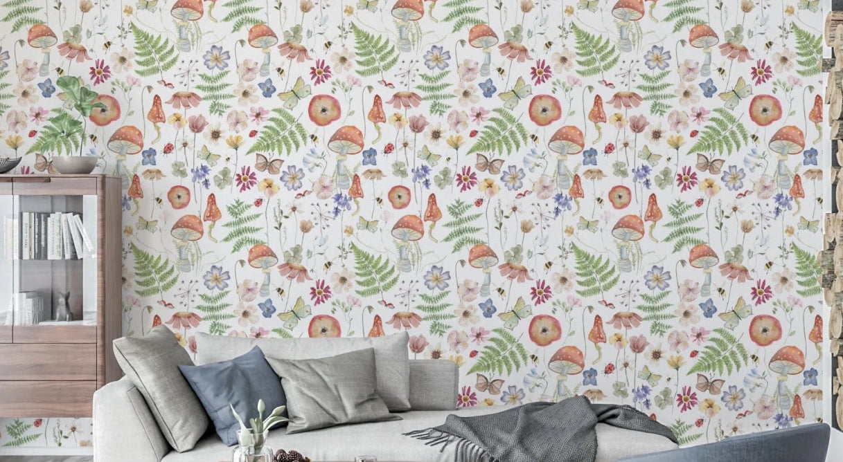 Whimsical Watercolor Meadow wallpaper mural in a living room with a beige sofa, blue cushions and wood cabinet