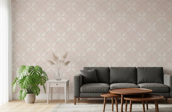 Whisper Arcs wallpaper in blush geometric lattice behind a charcoal sofa and monstera plant in a living room