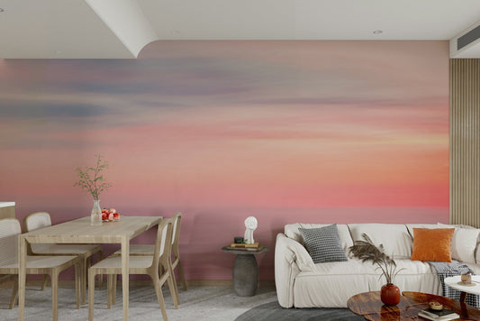 Whispers of Sunset wallpaper mural in pink, purple and orange sky across an open living and dining room with a cream sofa