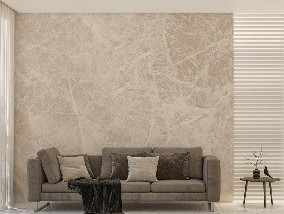 White Carrara Marble wallpaper mural with soft cream veining behind a taupe sofa and small round side table in a living room