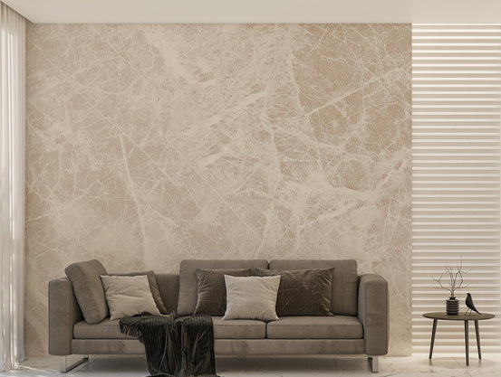 White Carrara Marble wallpaper mural with soft cream veining behind a taupe sofa and small round side table in a living room