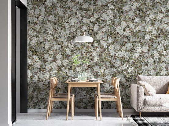 White Magnolia Floral wallpaper mural behind a light wood dining table and chairs with a beige sofa nearby