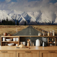 Snow-covered road wallpaper mural behind sofa in apartment lounge, calm winter landscape style