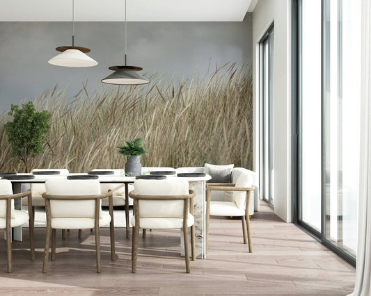 Woodland Dune Grass wallpaper showing beige wheat stalks swaying under grey sky.