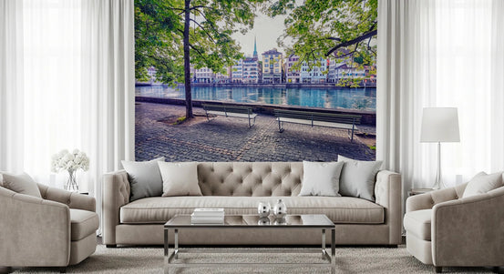 Zurich River Scene wallpaper mural of turquoise river and old town houses behind a beige tufted sofa and armchairs